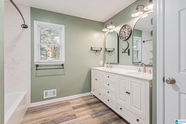 bathroom with shower / bath combination, vanity, and wood-type flooring