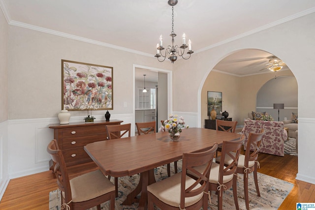 dining room with crown molding, hardwood / wood-style floors, and ceiling fan with notable chandelier