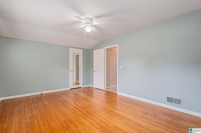 spare room featuring wood-type flooring, vaulted ceiling, and ceiling fan