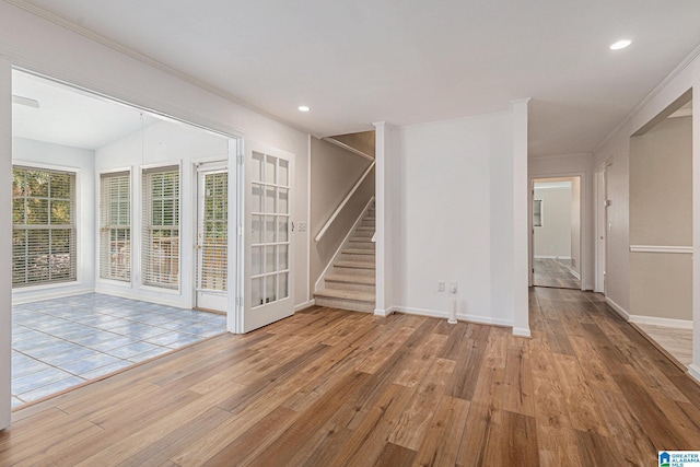 empty room with light hardwood / wood-style floors and crown molding