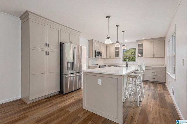 kitchen with pendant lighting, sink, dark hardwood / wood-style floors, a kitchen island, and stainless steel appliances