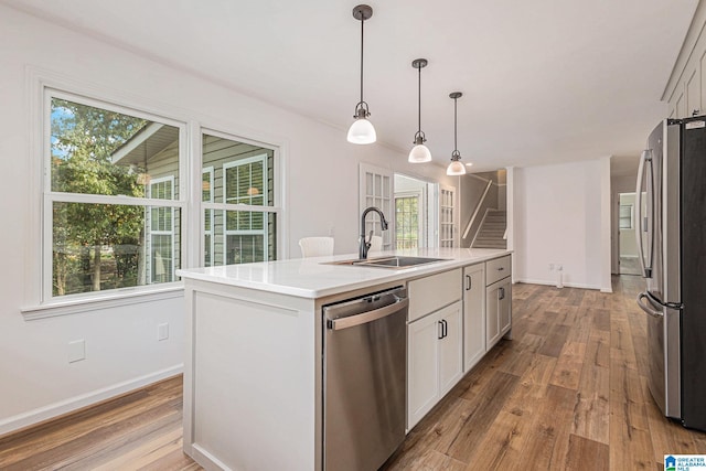 kitchen with a center island with sink, a healthy amount of sunlight, sink, and stainless steel appliances