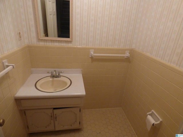 bathroom with tile patterned flooring, vanity, and tile walls