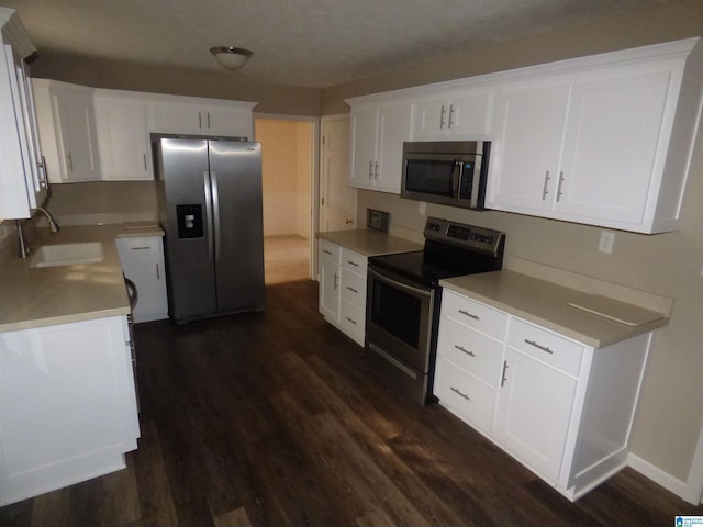 kitchen with white cabinets, stainless steel appliances, dark wood-type flooring, and sink