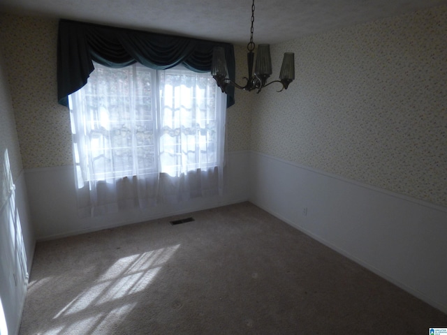 unfurnished dining area with carpet and a notable chandelier