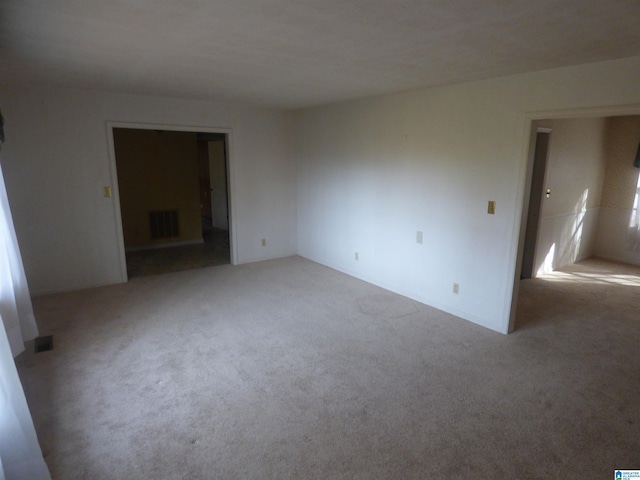 spare room featuring light colored carpet