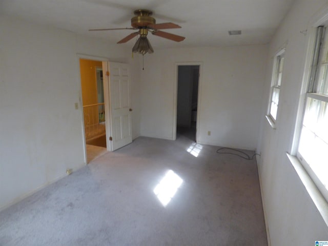 spare room featuring light colored carpet and ceiling fan