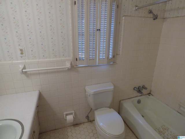 full bathroom with tile patterned flooring, tile walls, toilet, vanity, and bathtub / shower combination