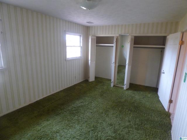 unfurnished bedroom with dark carpet