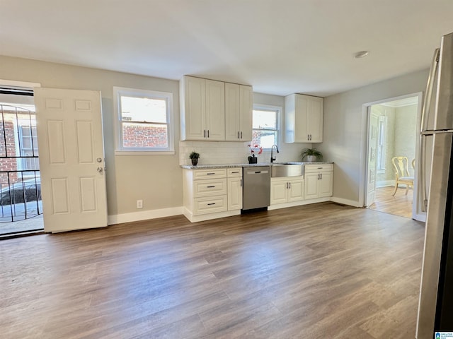 kitchen with decorative backsplash, a healthy amount of sunlight, wood-type flooring, and stainless steel appliances