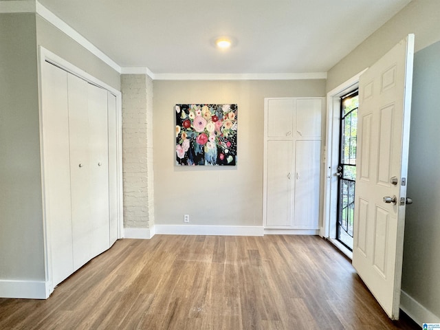 entryway featuring wood-type flooring and crown molding