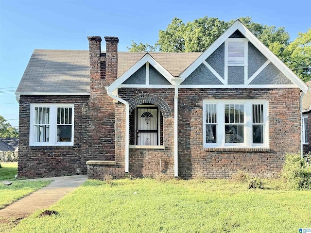 english style home with a front lawn