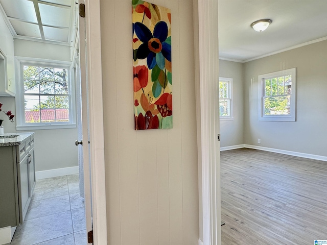 hallway with light hardwood / wood-style flooring and ornamental molding