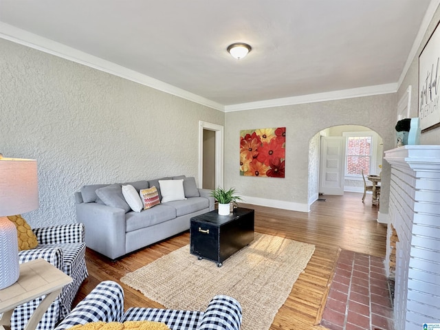 living room featuring a fireplace, hardwood / wood-style floors, and crown molding