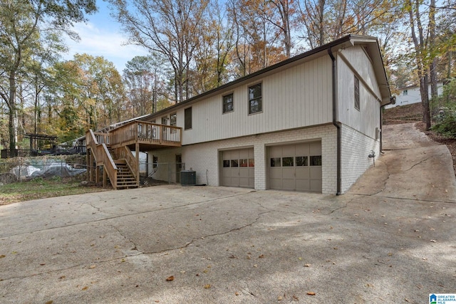 view of side of home with central AC unit, a deck, and a garage