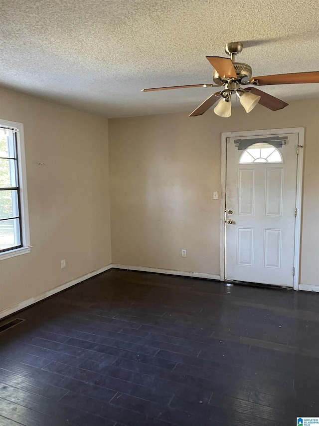 foyer featuring dark hardwood / wood-style floors, ceiling fan, and a textured ceiling