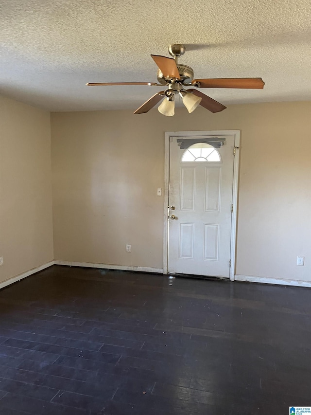 entryway with a textured ceiling, ceiling fan, and dark wood-type flooring