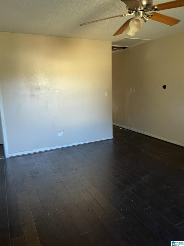 empty room featuring a textured ceiling and dark hardwood / wood-style floors