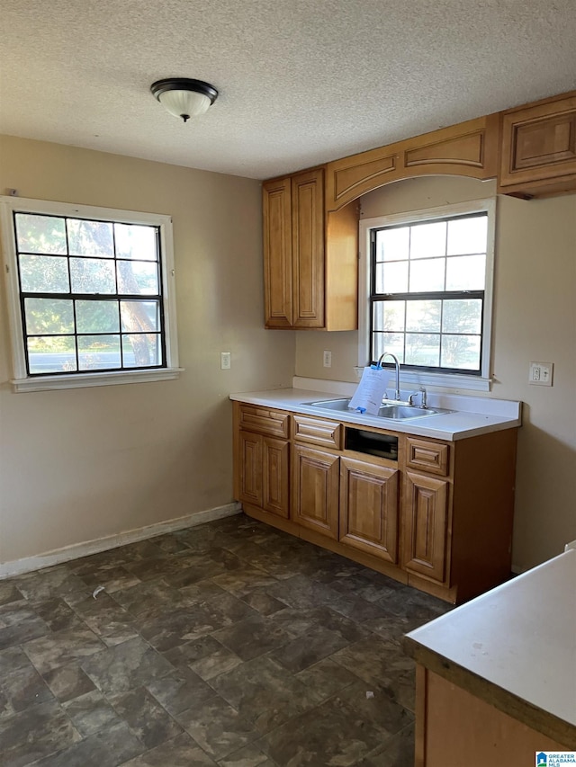 kitchen featuring a textured ceiling, plenty of natural light, and sink