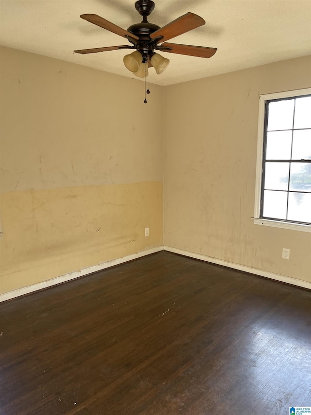 empty room featuring ceiling fan and dark wood-type flooring