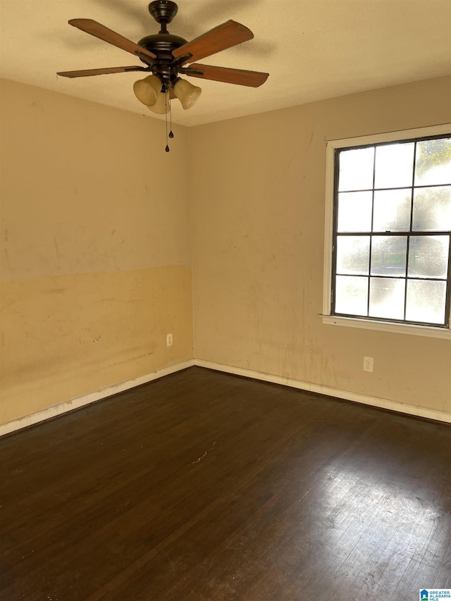 empty room featuring ceiling fan and dark wood-type flooring