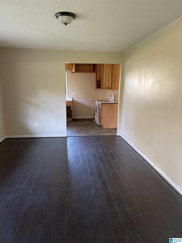 unfurnished living room featuring dark wood-type flooring and a textured ceiling