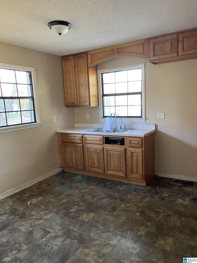 kitchen with a textured ceiling, sink, and a wealth of natural light