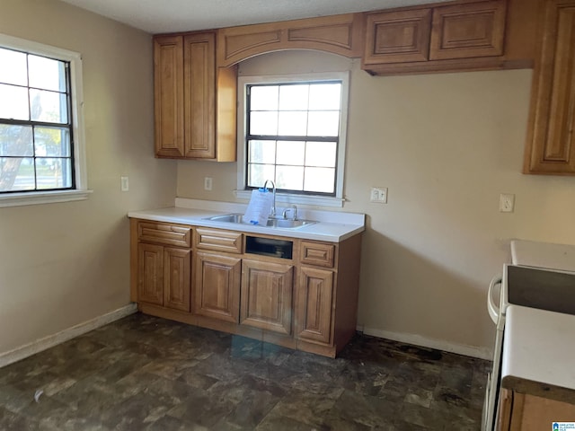 kitchen with stove, a healthy amount of sunlight, and sink