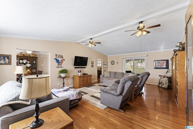 living room with ceiling fan, dark wood-type flooring, vaulted ceiling with beams, a textured ceiling, and ornamental molding