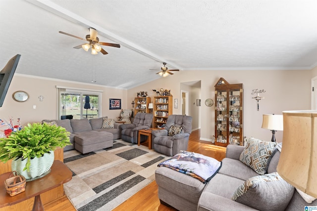 living room featuring ceiling fan, light hardwood / wood-style floors, ornamental molding, and vaulted ceiling