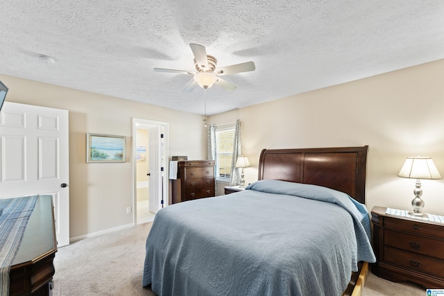 bedroom featuring a textured ceiling, ensuite bathroom, ceiling fan, and light colored carpet