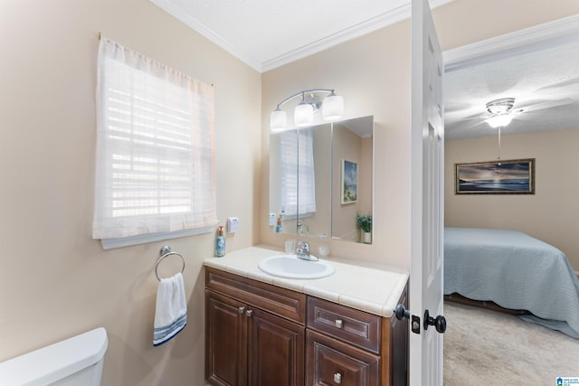 bathroom with vanity, toilet, ceiling fan, and crown molding