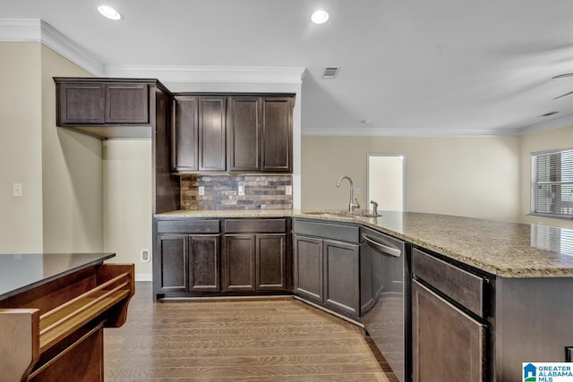 kitchen featuring sink, stainless steel dishwasher, hardwood / wood-style floors, decorative backsplash, and ornamental molding