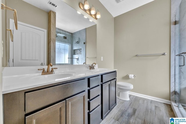 bathroom featuring toilet, a shower with door, vanity, and hardwood / wood-style flooring