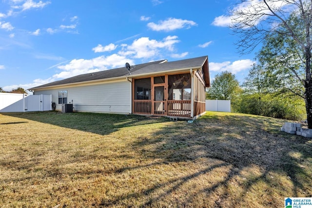 rear view of property featuring a sunroom, a yard, and central air condition unit