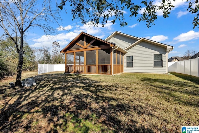 rear view of property with a sunroom and a lawn