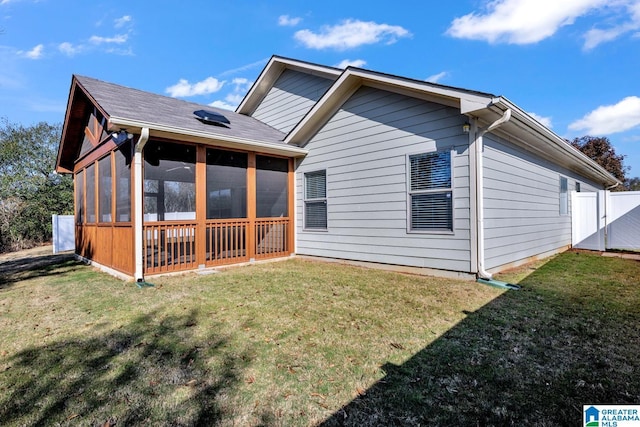 back of house with a lawn and a sunroom