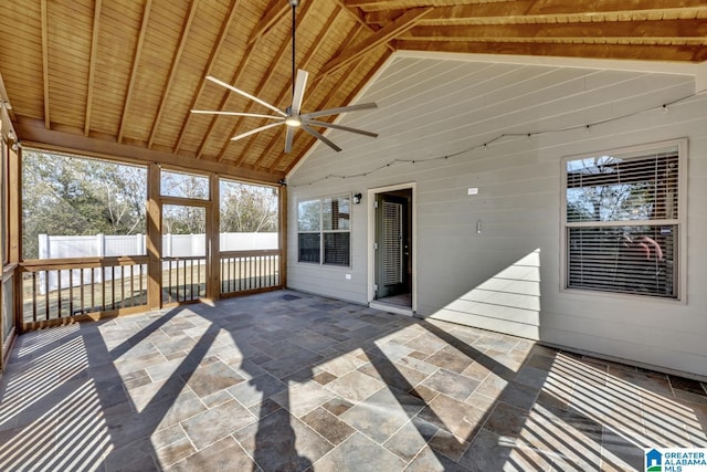 unfurnished sunroom with ceiling fan, vaulted ceiling with beams, plenty of natural light, and wood ceiling