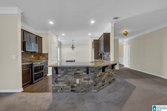 kitchen featuring dark colored carpet, appliances with stainless steel finishes, backsplash, and ornamental molding