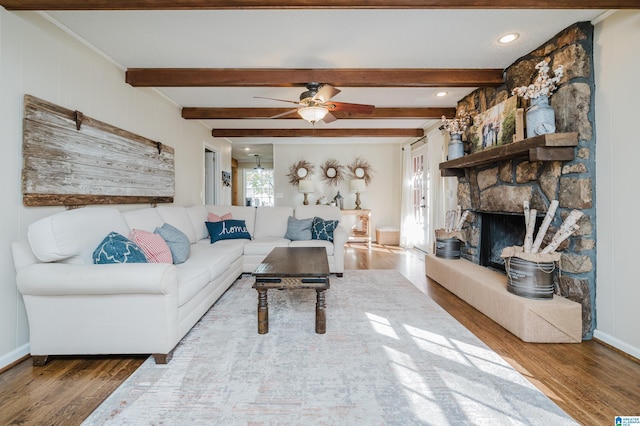 living room featuring a fireplace, wood-type flooring, ceiling fan, and beam ceiling