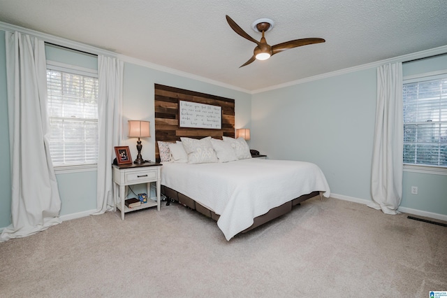 bedroom featuring a textured ceiling, ceiling fan, light colored carpet, and crown molding