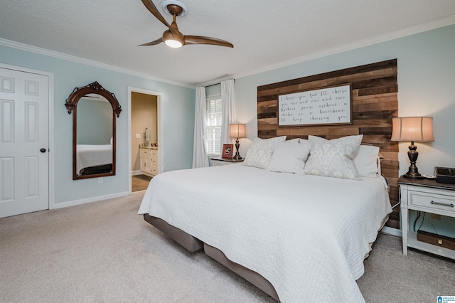 carpeted bedroom with ensuite bath, a textured ceiling, ceiling fan, wooden walls, and crown molding