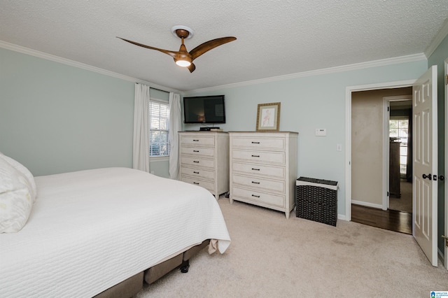 carpeted bedroom featuring ceiling fan, crown molding, a textured ceiling, and multiple windows