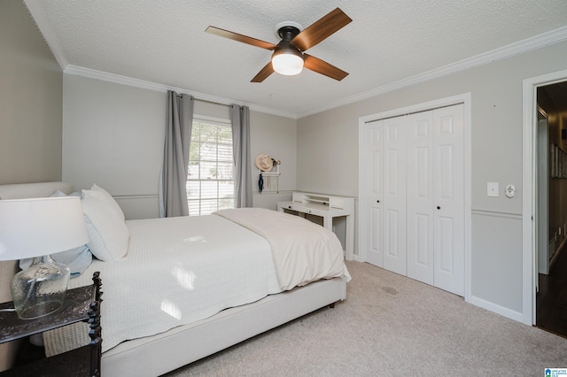 bedroom with ceiling fan, a closet, light carpet, and a textured ceiling