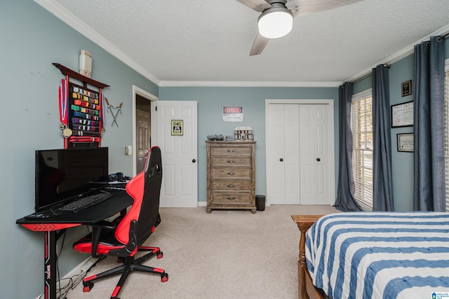 carpeted bedroom featuring ceiling fan, ornamental molding, a textured ceiling, and a closet