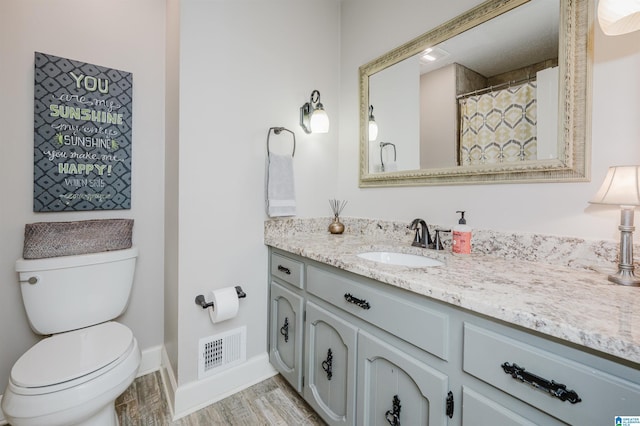 bathroom with vanity, hardwood / wood-style flooring, and toilet