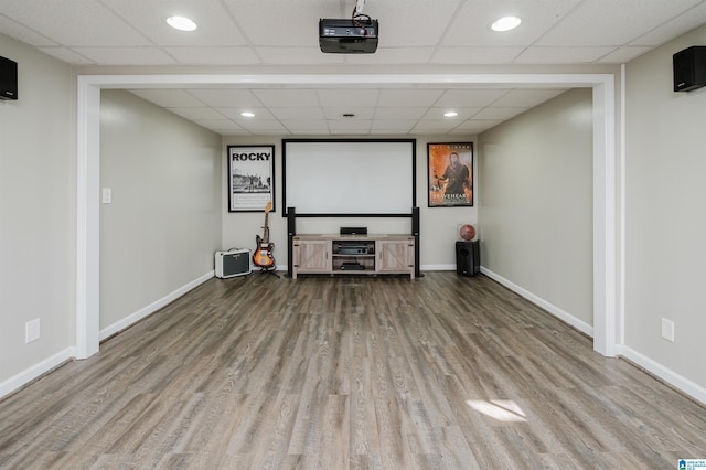 cinema room featuring a drop ceiling and light hardwood / wood-style flooring