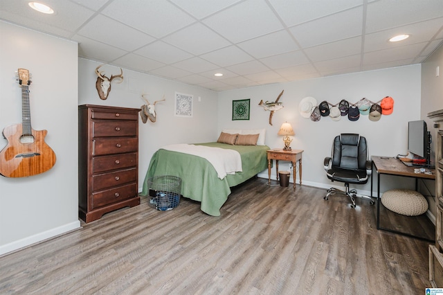 bedroom featuring a paneled ceiling and hardwood / wood-style flooring