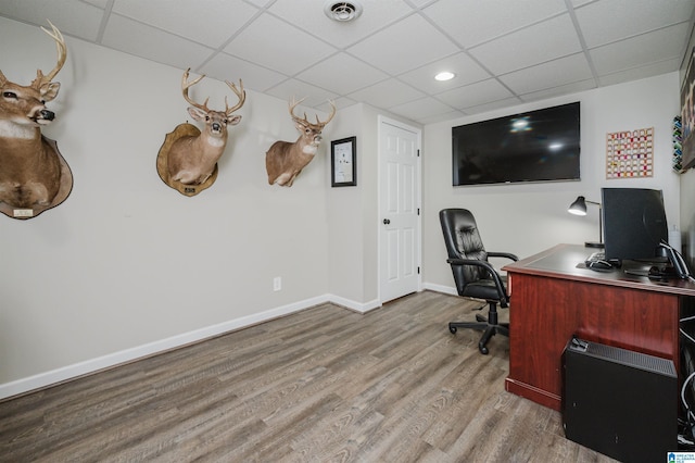 office space featuring a paneled ceiling and light hardwood / wood-style floors