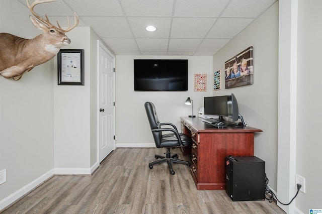 office featuring a paneled ceiling and light hardwood / wood-style flooring